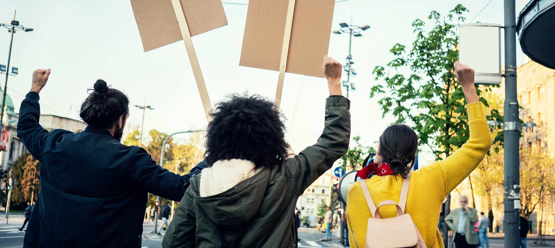 People marching and holding signs viewed from behind