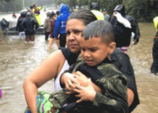 Adult carrying child through flooded area
